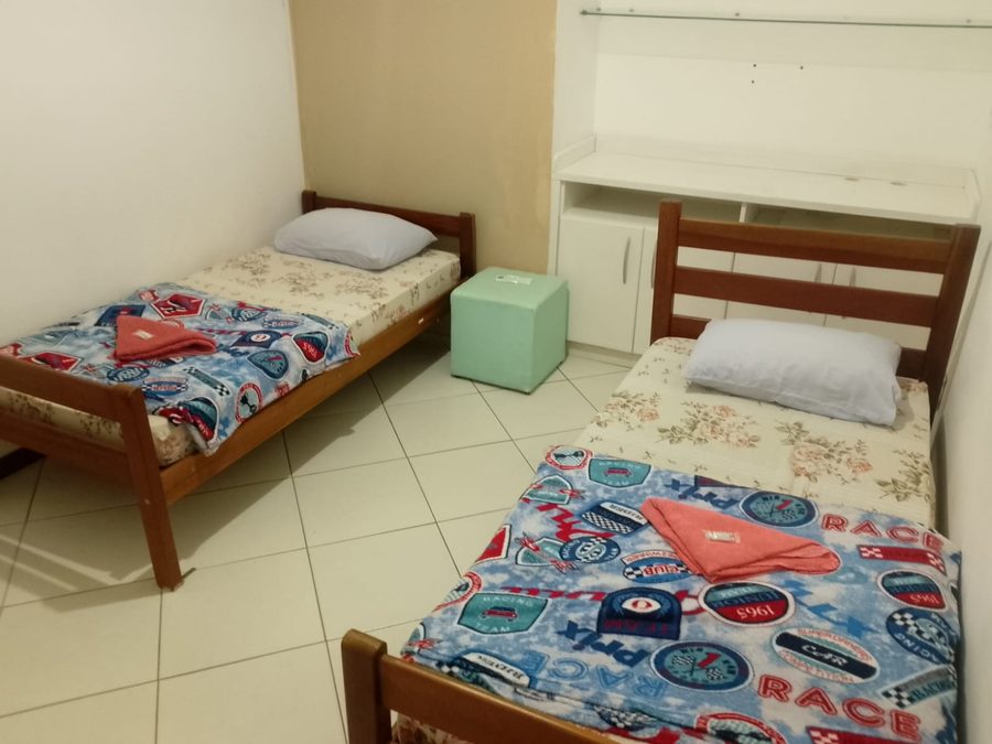 Quarto duplo com varanda, duas camas de solteiro e bancada de apoio